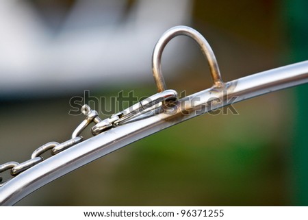 silver heavy chain attached to metal bar via a metal clasp