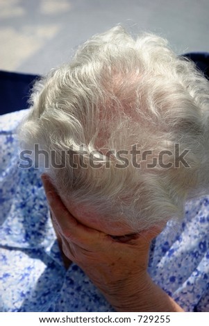old lady crying holding her face with her hand