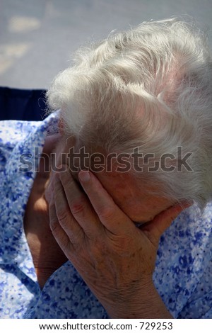 old lady holding her head and crying