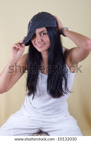 smiling black hair young woman in cap portrait. studio shot.