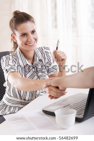 Young business woman shaking hands above a release.