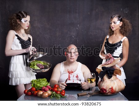 Young girls serving raw pig heart to a fat man