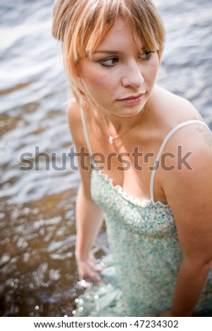 woman getting her dress wet in the water