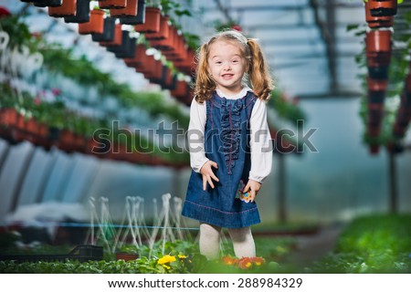 people - children, gardening and profession concept - happy children  taking care of flowers in greenhouse