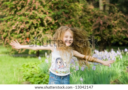 Happy girl with hands open, with trees and flowers on background
