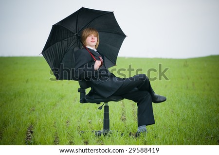 Handsome businessman with umbrella outside ? protection concept