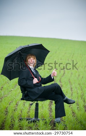 Smiling businessman with umbrella outside - protection concept