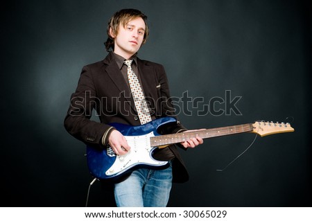 Man playing electro guitar, studio shot