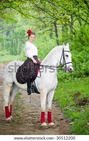 Beautiful girl riding horse in the forest
