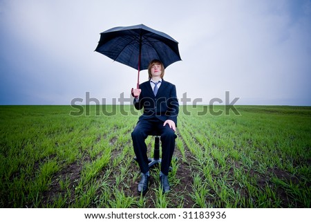 Businessman with umbrella outside - protection concept