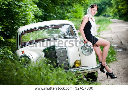 stock photo Beautiful pinup styled girl sitting on retro car