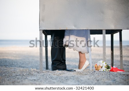 Bride and groom kissing in dressing cabin on the beach