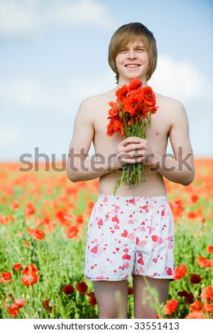 Smiling young man with bouquet of poppies