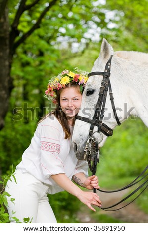 Smiling cute girl with horse in the forest