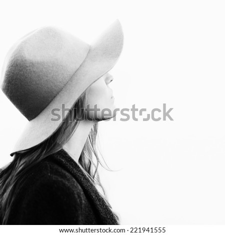 portrait of cute girl with face hidden under the hat. Standing in profile to camera. Outside