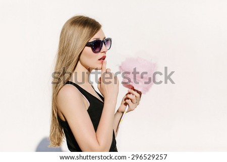 Close up portrait of young sexy surprised woman with pink cotton candy. Lifestyle portrait. White background, not isolated
