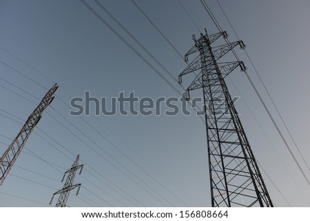 The afterglow of the transmission tower high voltage electrical network,electricity poles.