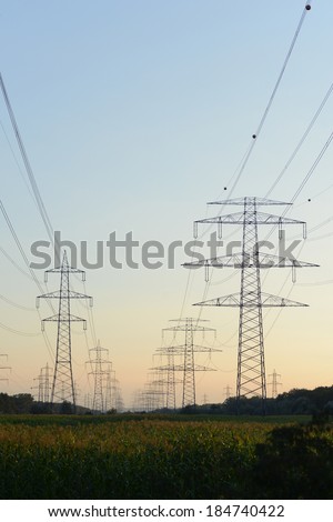 The afterglow of the transmission tower high voltage electrical network,electricity poles.