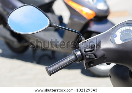 Scooter handlebar and rearviewmirror. Motorbike parking. Traffic security concept.