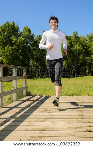 Sportsman running in park outside. Handsome young athlete running and working out on summer day.