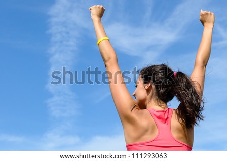 Woman freedom happy concept. Successful woman raising arms to clear blue sky. Beautiful and joyful caucasian girl.