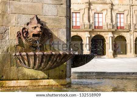 Gijon, Asturias, Spain. Lion fountain of monument to Don Pelayo and Palacio de Revillagigedo on background. Tourist attraction. Plaza Marques.