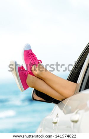 Car road trip vacation concept. Woman legs out the windows on sea background. Female legs out of window for freedom, travel and relax concept. Copy space