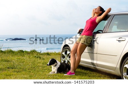 Happy Woman And Dog Enjoying Travel And Peace On Summer. Beautiful Girl And Her Pet On Road Trip To Coast. Copy Space.