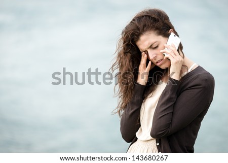Sad crying woman talking on the phone. Emotional crisis, troubles and love depression concept.
