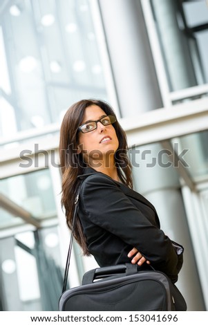 Successful business brunette woman portrait looking confident and standing outside corporate building with arms crossed. Executive businesswoman success.