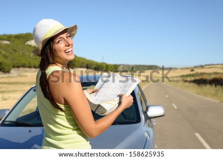 Young woman on car road travel looking map. Brunette hispanic girl having fun on summer journey.