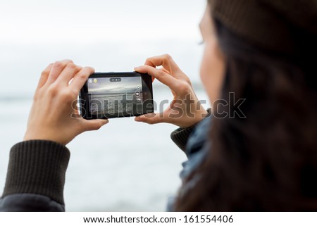 GIJON SPAIN- November 04 2013 Woman taking photos with Nokia Lumia 1020 smartphone featuring Nokia's PureView 41 megapixel camera GIJON SPAIN- November 04 2013 Woman taking photos with Nokia Lumia 1020 smartphone featuring Nokia's PureView 41 megapixel camera