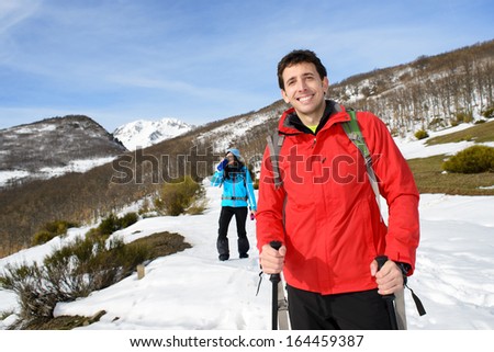 Couple hiking in mountain on winter. Sporty man and woman on adventure trip.