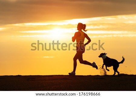 Woman And Dog Running Free On Beach On Golden Sunset. Fitness Girl And Her Pet Working Out Together.