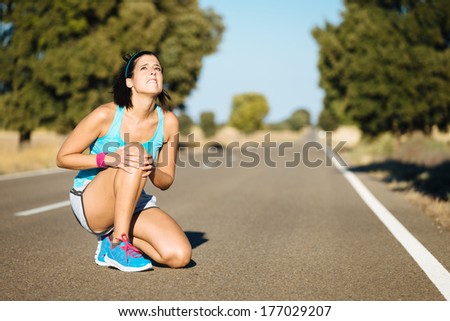 Woman crying for a painful knee injury during running training.