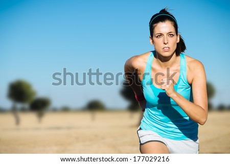 Cross country running sweaty woman. Female runner on countryside training.