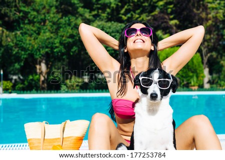 Funny dog and woman on summer vacation at swimming pool.