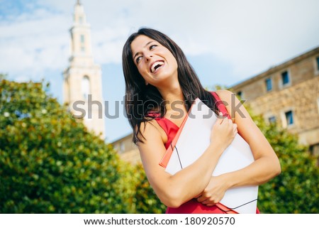 Successful female student smiling at european university campus.