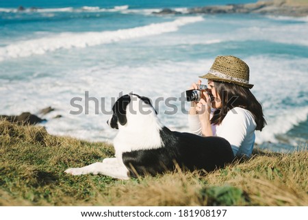 Happy hipster woman taking photo to her dog on vacation travel.
