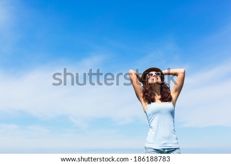 Joyful funky woman on copy space sky background. Brunette girl enjoying freedom and leisure on summer or spring.