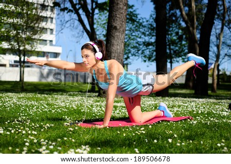 Fitness spring or summer workout outdoor. Fit woman working out and doing stretching exercises in city park.