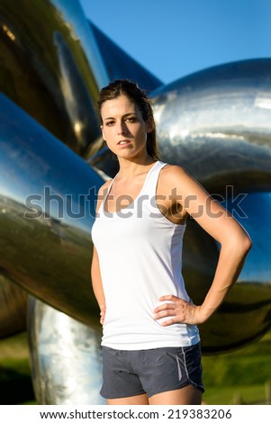 Motivated female athlete ready for running and outdoor fitness workout. Fit beautiful woman exercising on summer.