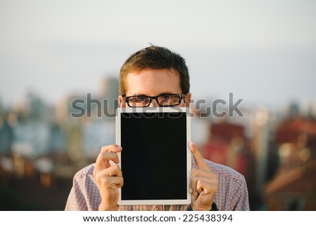 Casual city man showing digital tablet copy space screen. Smart geek holding touch pad.
