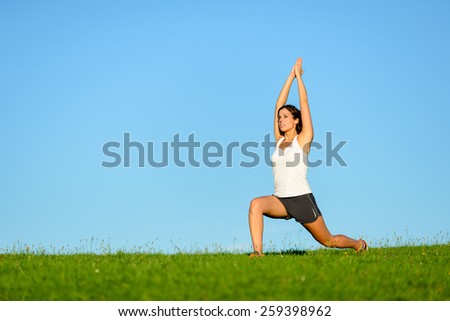 Sporty woman stretching legs and arms. Brunette fit girl on outdoor relaxing and breathing exercise workout outdoor.