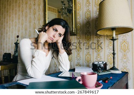 Tired and overwhelmed young woman studying or working at home. Bored female entrepreneur or student. Professional frustration and stress.