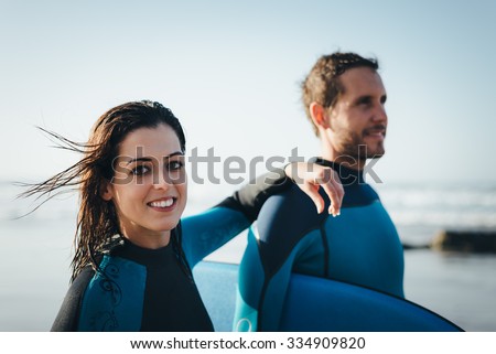 Young couple of bodyboard surfers. Surfing and outdoor sport lifestyle concept. Woman and man after bodyboarding.