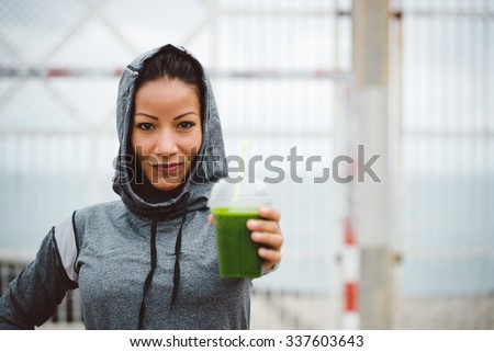 Successful urban sporty woman taking a rest for drinking nutritive detox smoothie. Fitness nutrition and healthy lifestyle concept.