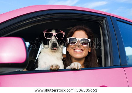 Woman and dog in pink car on summer road trip vacation. Funny dog with sunglasses traveling. Travel with pet concept.