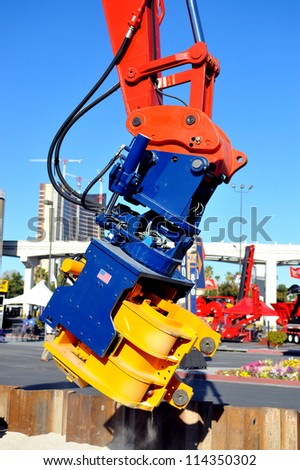 Industrial piece of machinery pounds steel into the ground during the construction of commercial property construction.