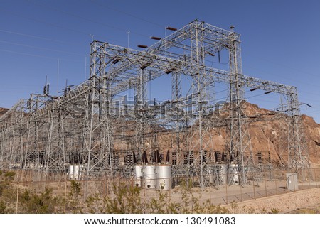 Huge power transformers manage the electricity from Hoover Dam. An electric buzzing sound fills the air.